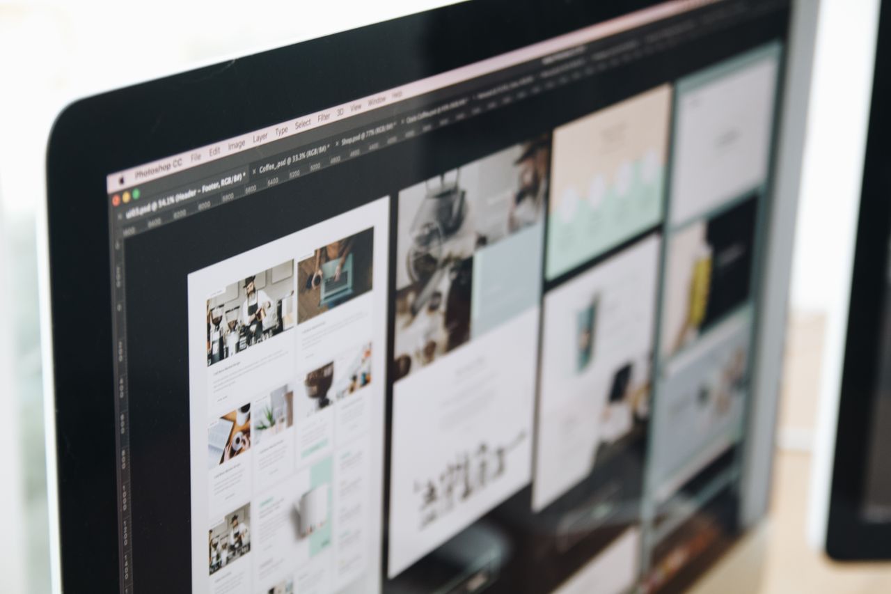 Un écran d’ordinateur moderne affichant un travail de conception web, avec des visuels créatifs dans un espace de travail.
